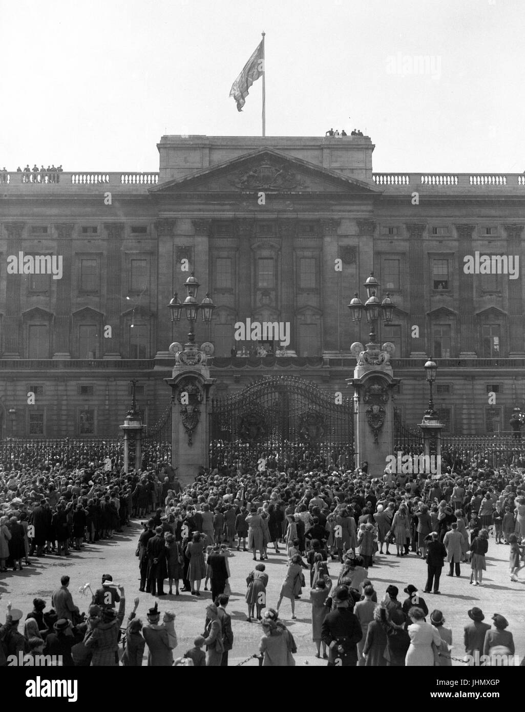 Die überfüllten Szene vor den Toren des Buckingham Palace als König George VI und Königin Elizabeth mit der Duke of Edinburgh, Prinzessin Elizabeth, Duke und Duchess of Gloucester, Prinzessin Margaret und Queen Mary. Stockfoto