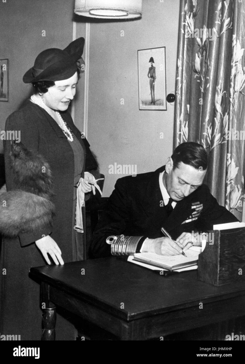 König George VI und Königin Elizabeth, die Unterzeichnung der Besucher buchen im kürzlich eröffneten Y.M.C.A. King George im sechsten Club in London nach einem Spaziergang im Inneren unangemeldet. Stockfoto