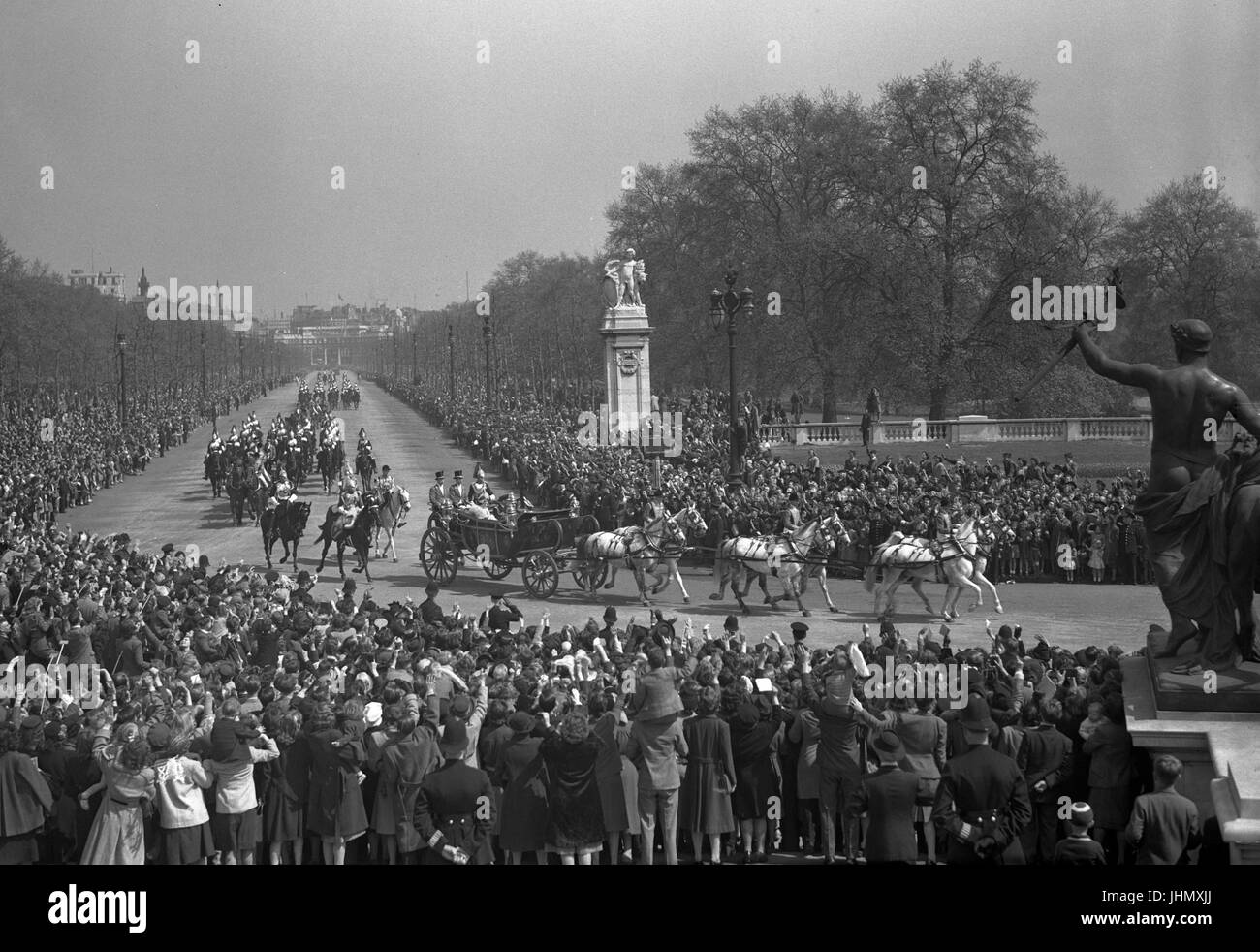 Die jubelnde Menge der Strecke als König George VI. und Königin Elizabeth und Prinzessin Margaret, zurück über die Mall zum Buckingham Palace aus St. Pauls Cathedral. Ein Teil der das Victoria Memorial ist auf der rechten Seite ersichtlich. Stockfoto