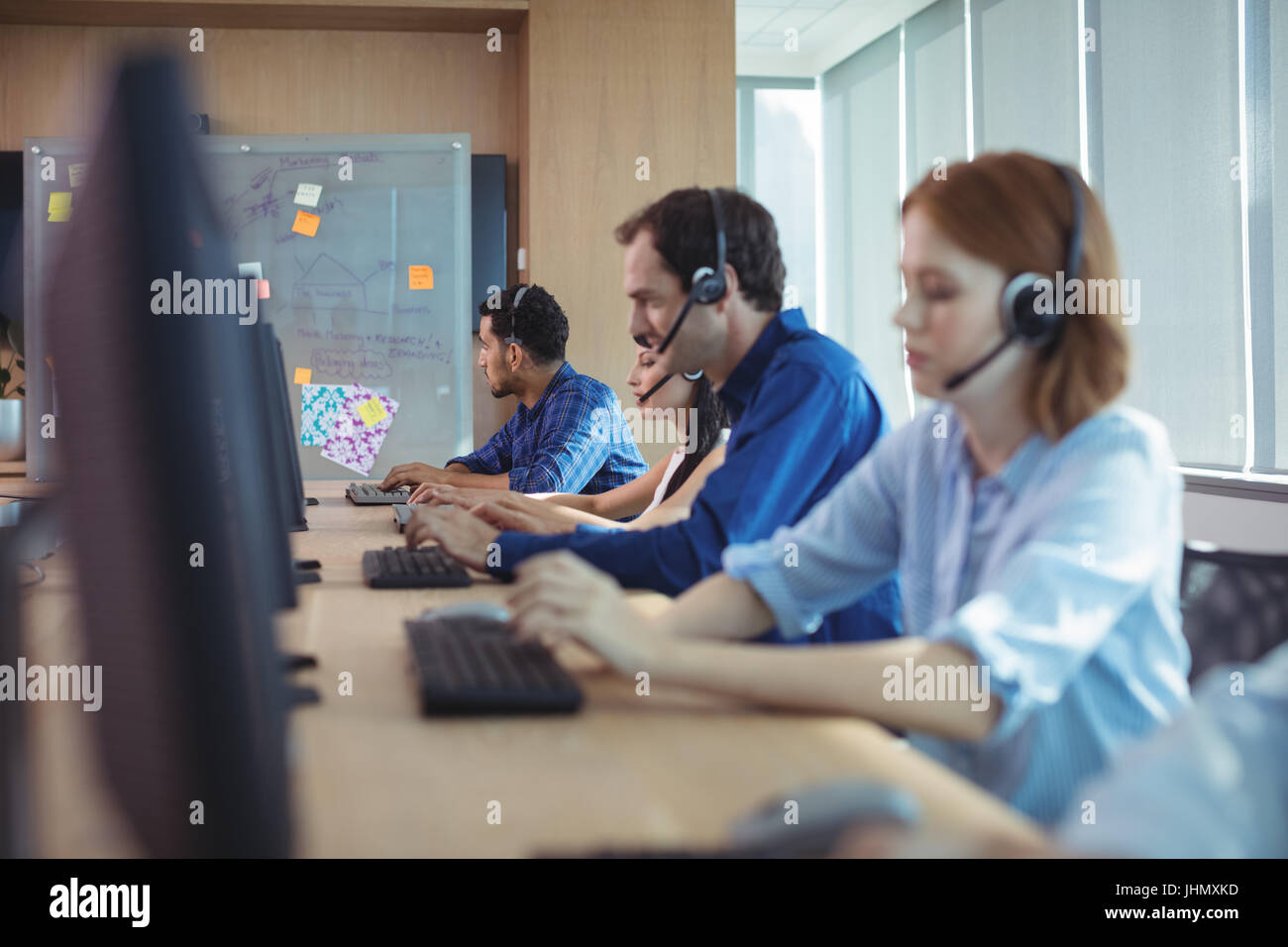 Geschäftsleute, die Arbeiten am Schreibtisch im Call-center Stockfoto