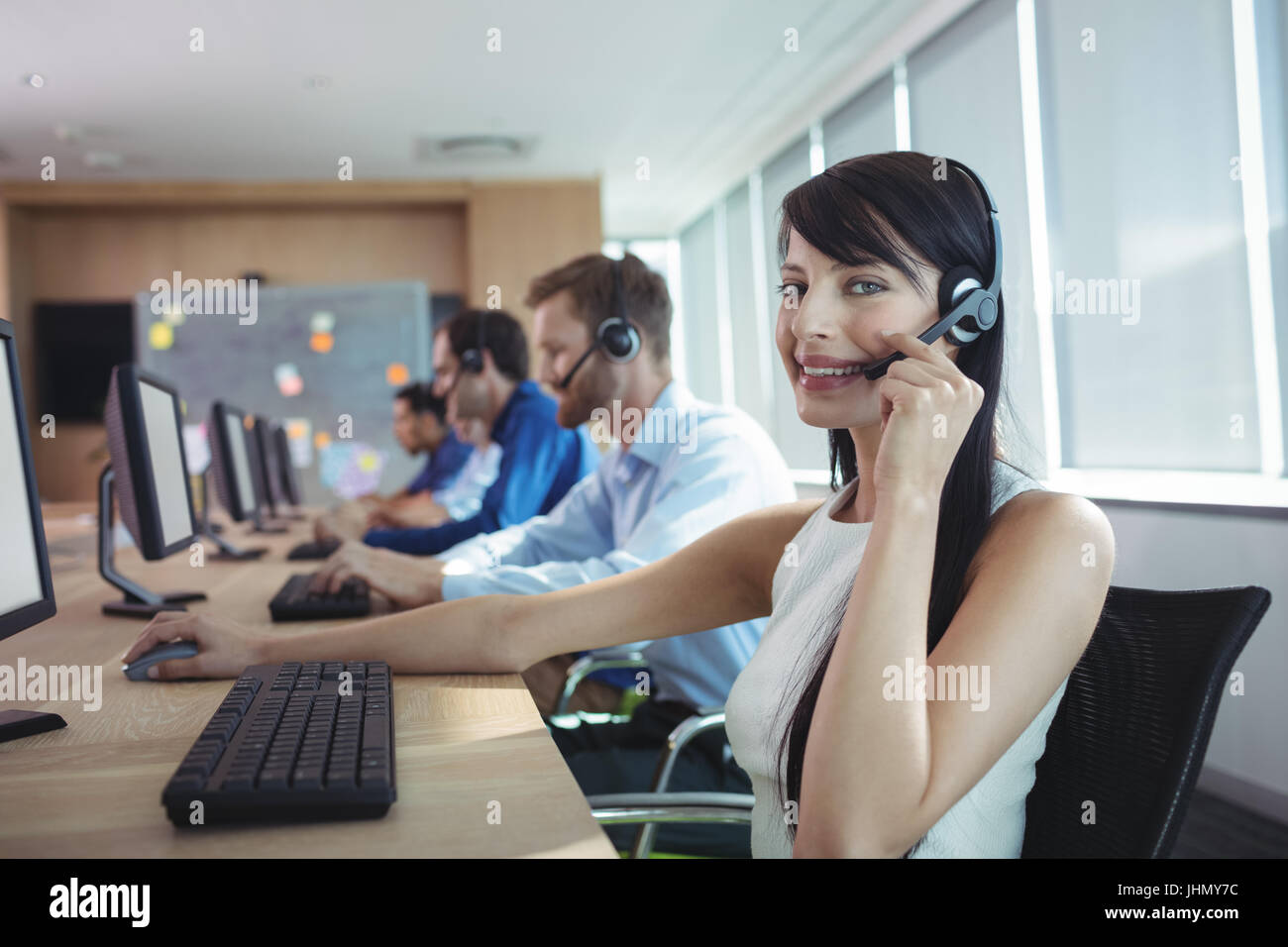 Porträt von glücklich Geschäftsfrau mit Kopfhörer an Call-center Stockfoto