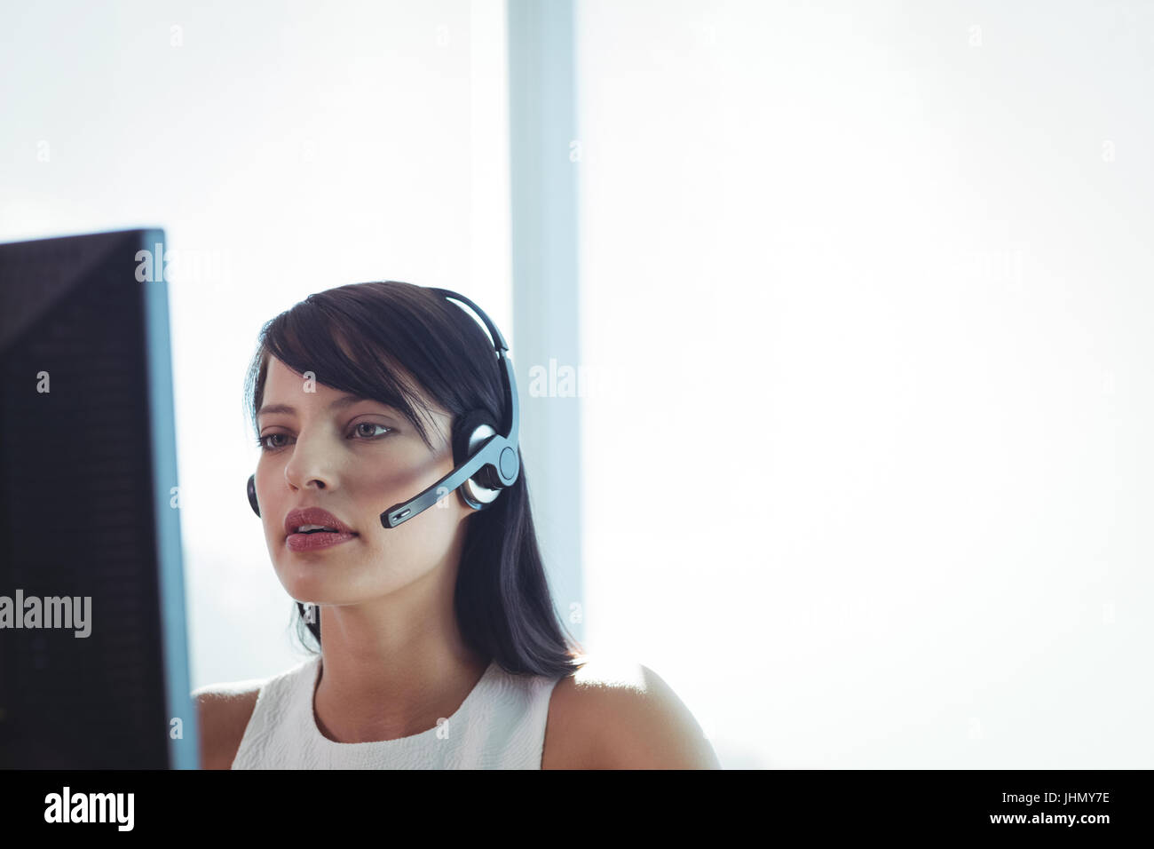 Junge Geschäftsfrau tragen Kopfhörer während der Arbeit am Computer im Call-center Stockfoto