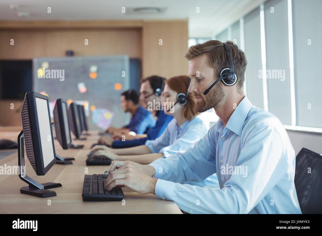 Seitenansicht der Geschäftsmann Tippen auf Tastatur am Schreibtisch im Call-center Stockfoto