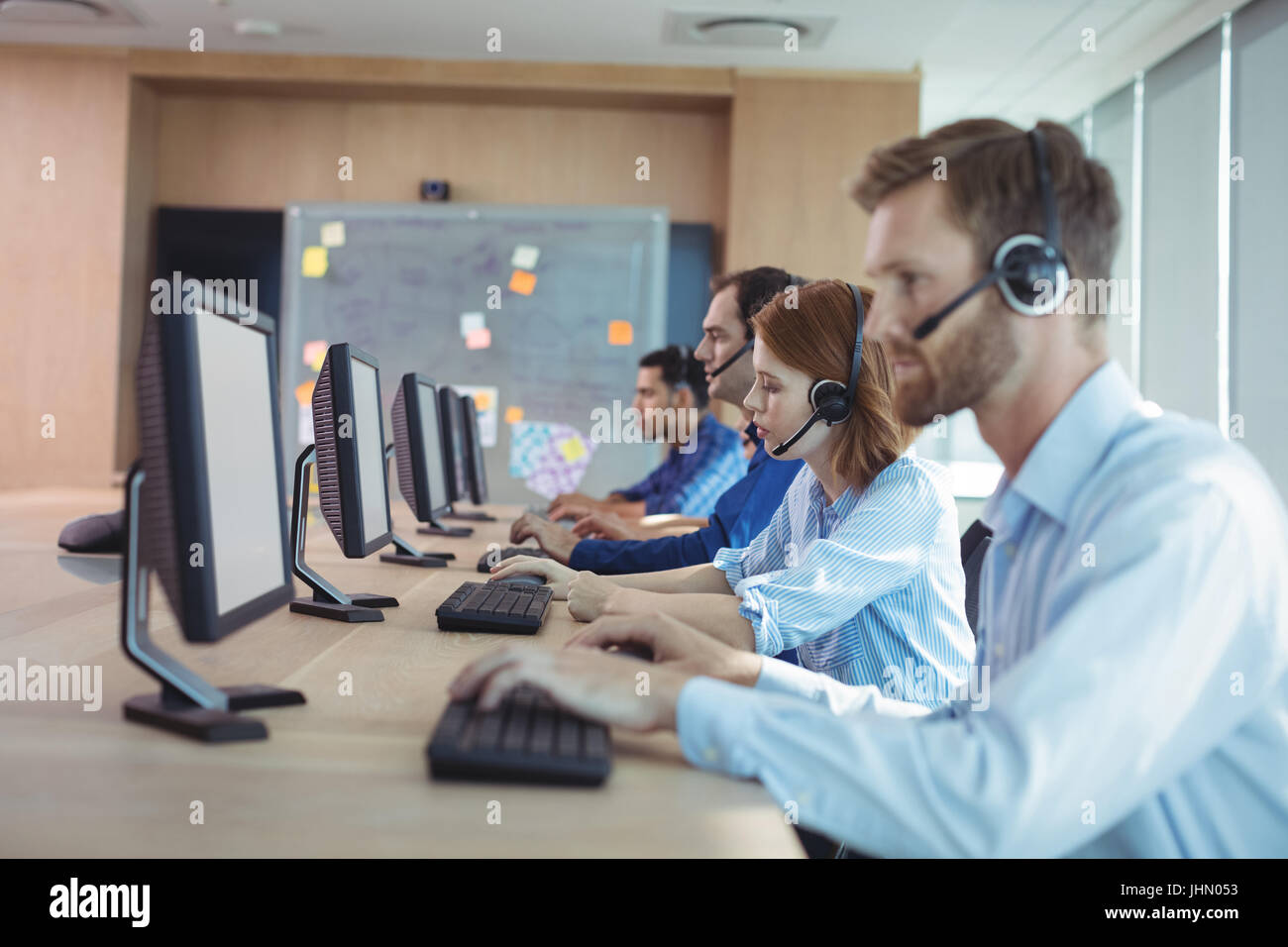 Seitenansicht der Geschäftsleute arbeiten am Schreibtisch im Call-center Stockfoto