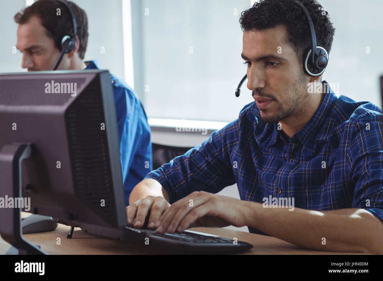 Fokussierte Geschäftsmann arbeiten am Computer am Schreibtisch im Call-center Stockfoto