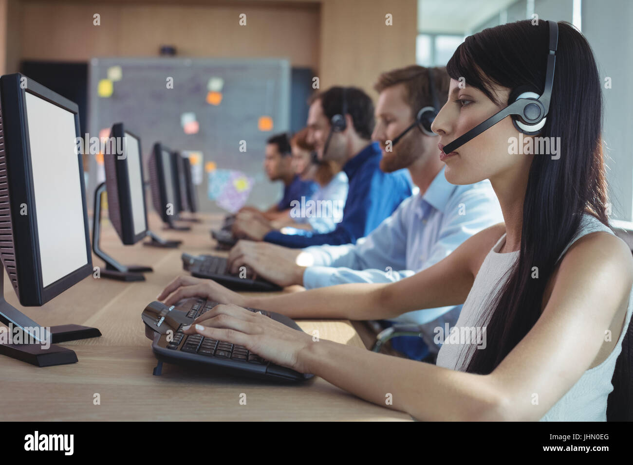 Seitenansicht der Geschäftsfrau Tippen auf Tastatur am Schreibtisch im Call-center Stockfoto
