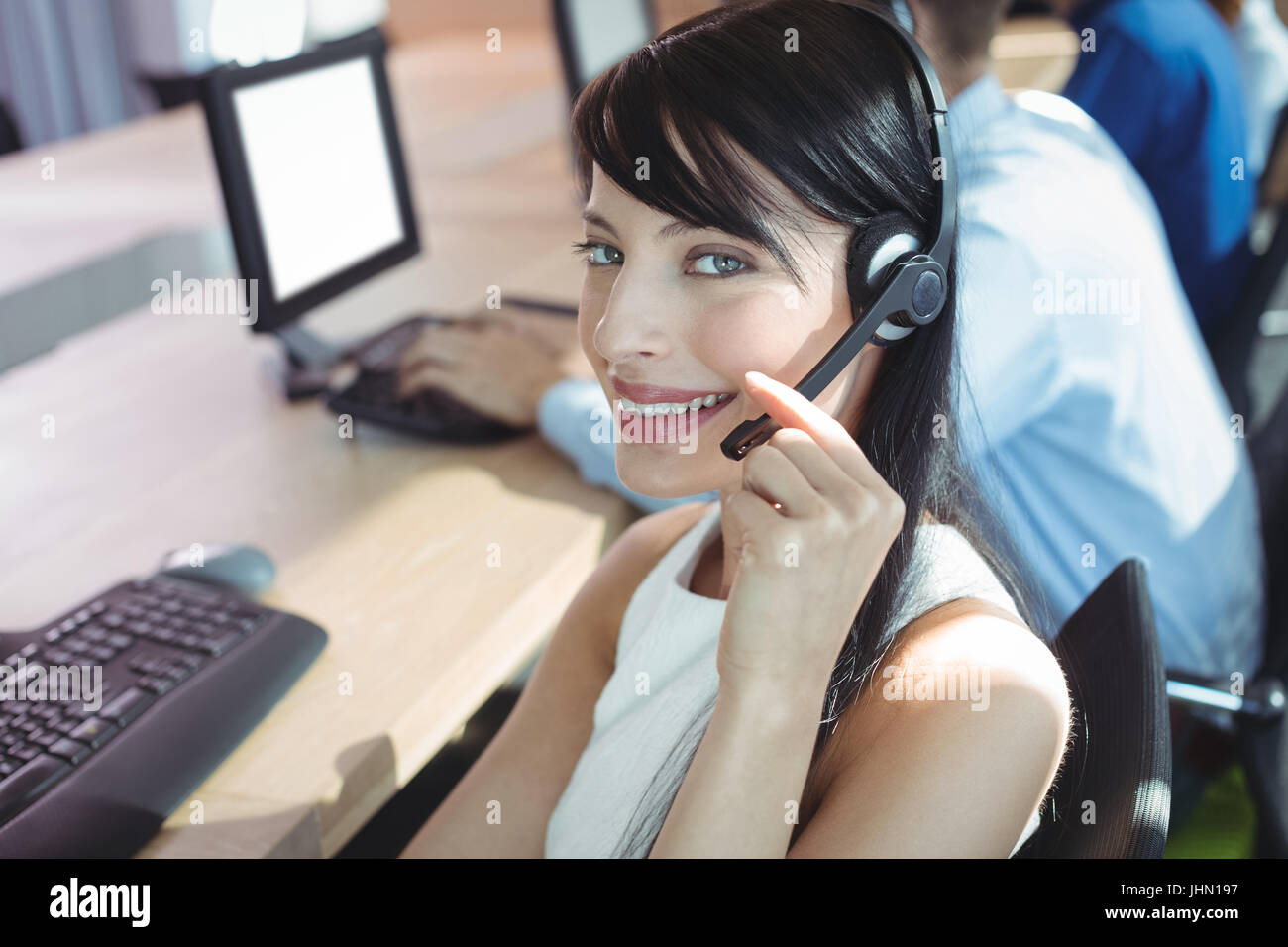 Porträt der jungen Unternehmerin mit Kopfhörer an Call-center Stockfoto