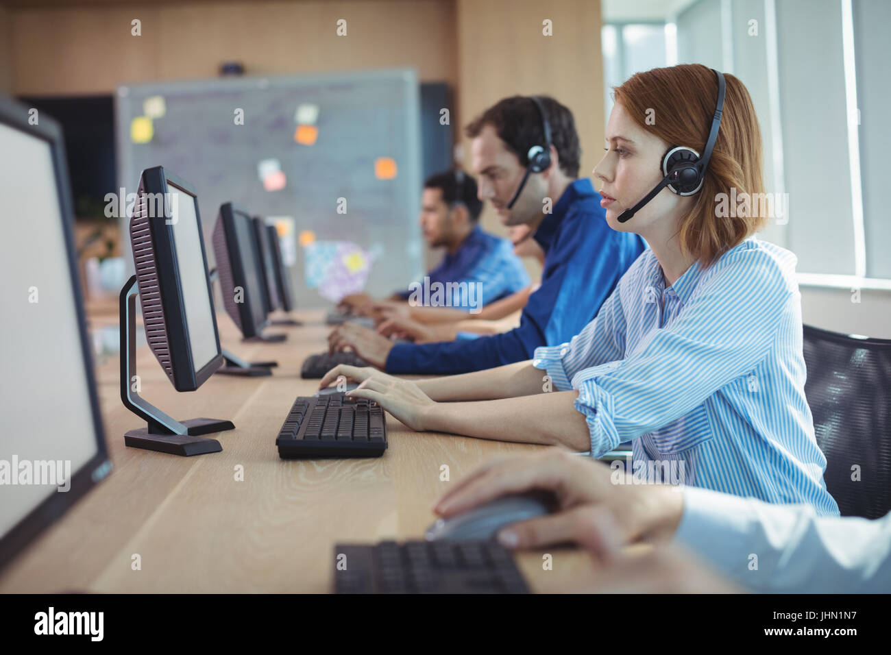 Seitenansicht der Geschäftsfrau arbeiten am Schreibtisch im Call-center Stockfoto