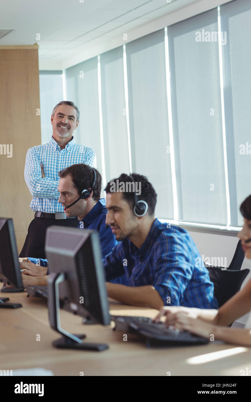 Porträt von lächelnden Supervisor mit Business-Team arbeiten am Schreibtisch im Call-center Stockfoto