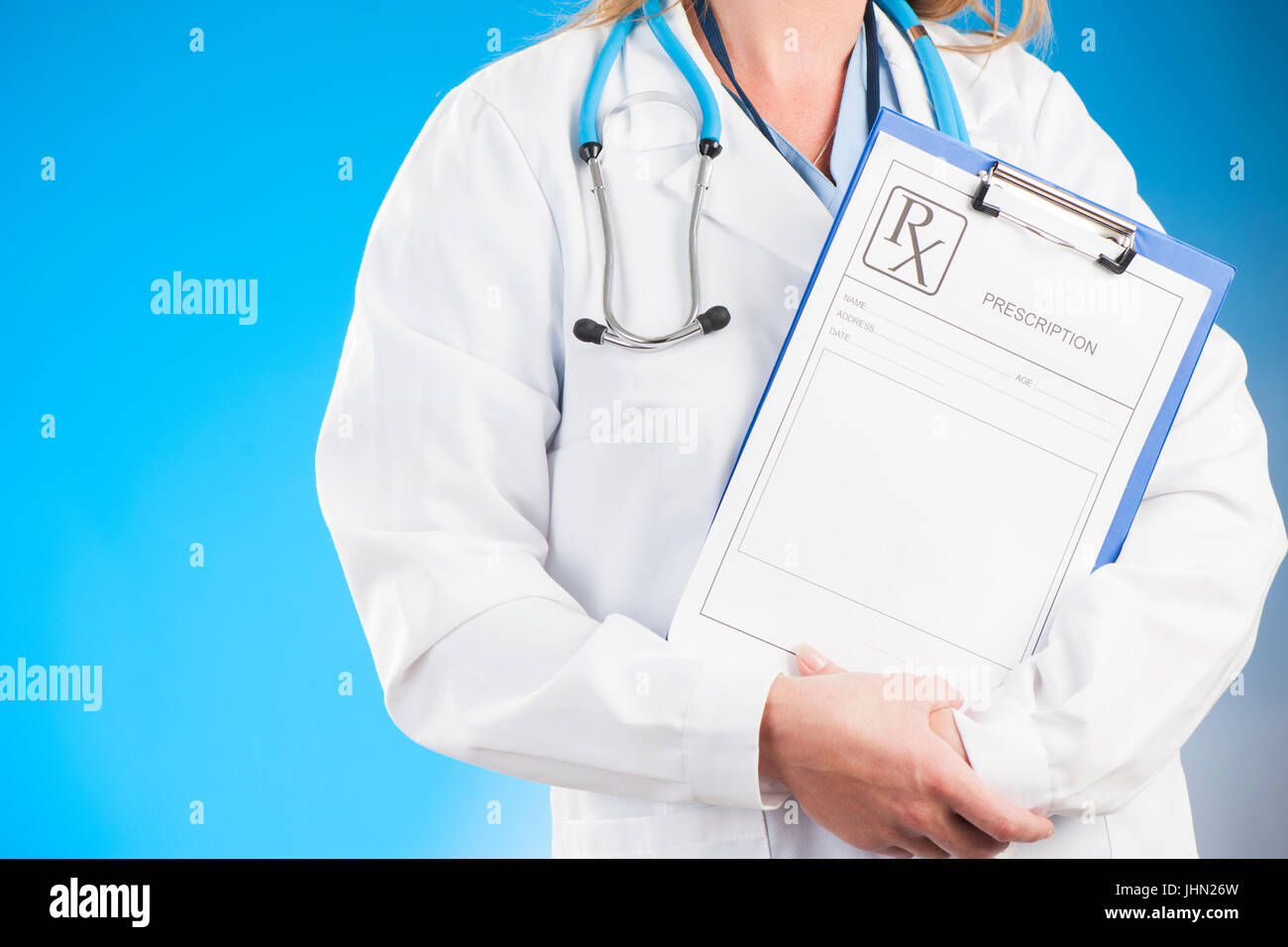Ärztin mit Zwischenablage auf blauem Hintergrund Stockfoto