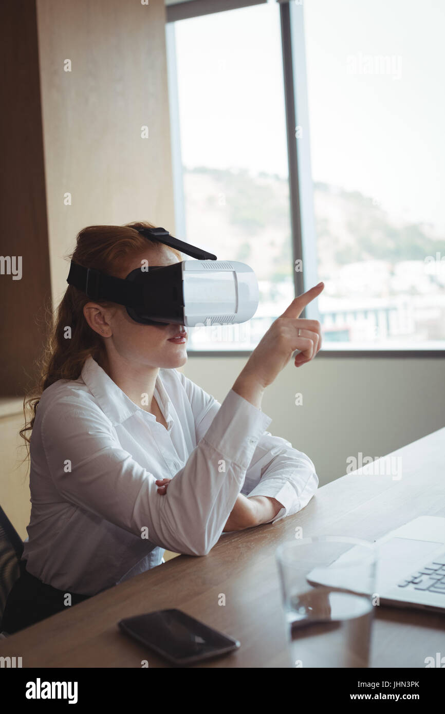 Geschäftsfrau, die Antizipation während der Verwendung von virtual Reality-Technologie am Schreibtisch im Büro Stockfoto