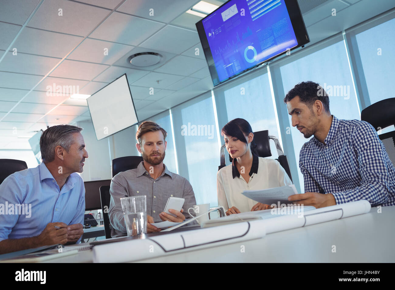 Kippen Sie Bild von Geschäftsleuten diskutieren am Schreibtisch im Büro Stockfoto