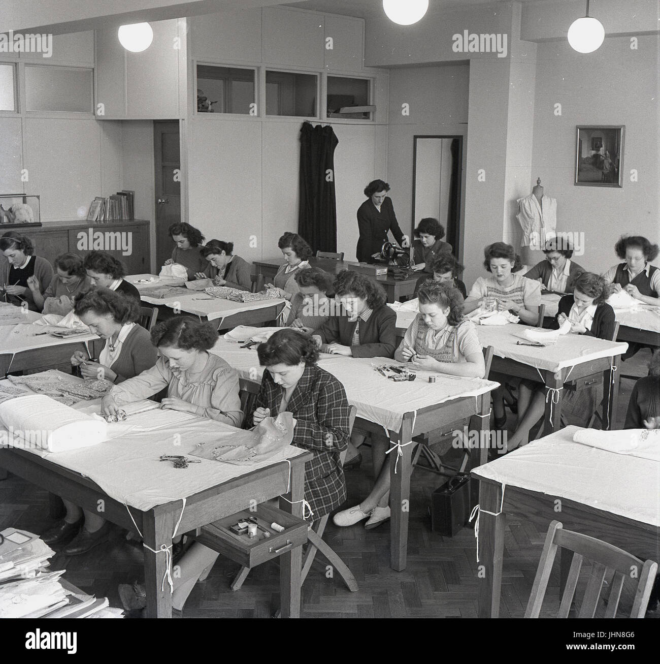 1948, historische, England, Bild zeigt weibliche Studierende in einem nähen Klasse auf einen Teachers Training College, mit einem Lehrer beaufsichtigt ein Student mit einer Nähmaschine. Stockfoto