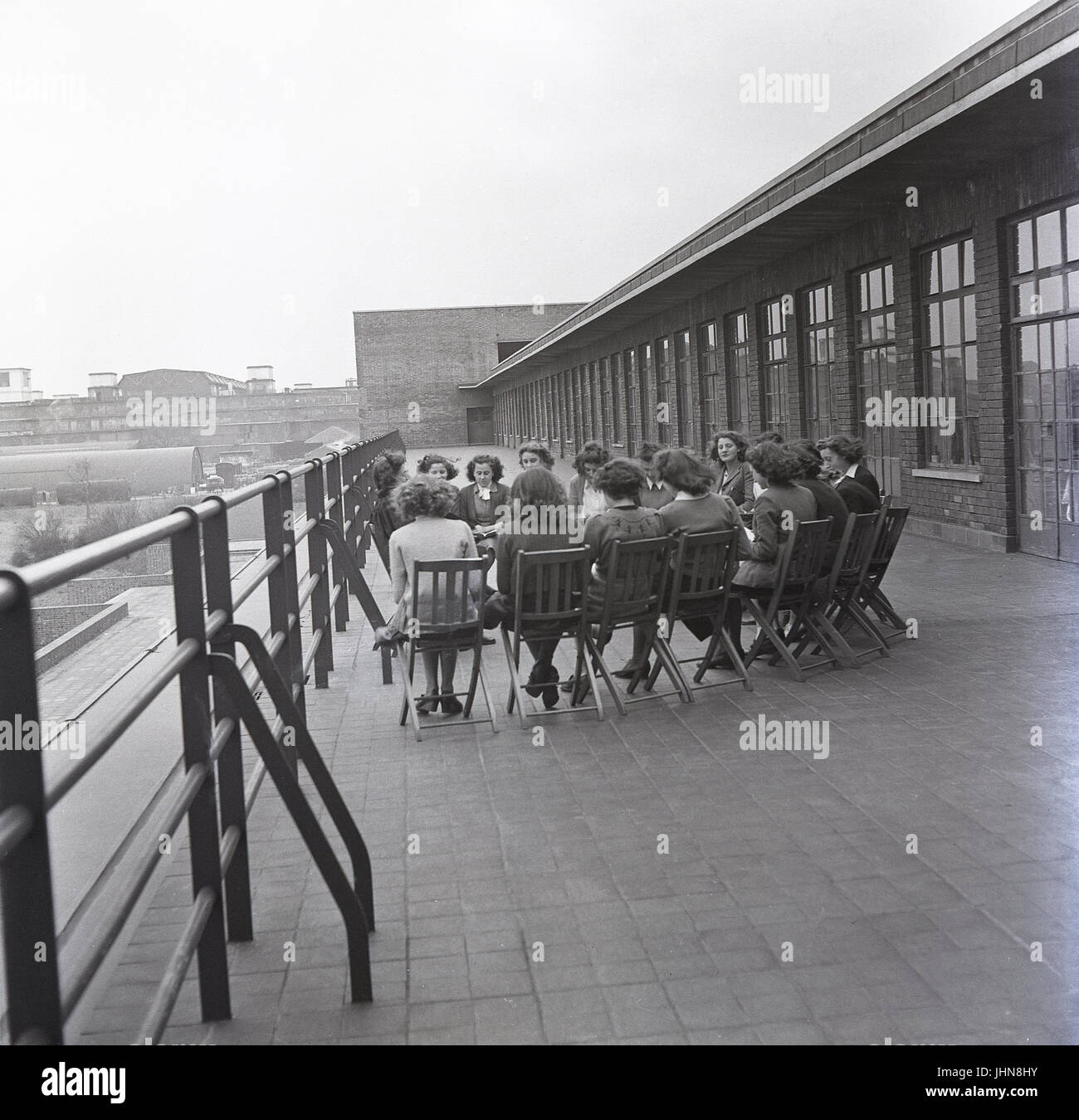 1950, historische, England, Gruppe der weiblichen Studierenden an einer Frauen Teachers Training College haben die Klasse mit ihrer Lehrerin draußen auf dem Balkon. Stockfoto