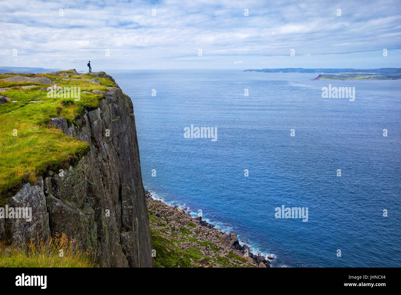 Tourist mit Rucksack stehend auf der Klippe Fair Kopf, Nordirland, Vereinigtes Königreich Stockfoto