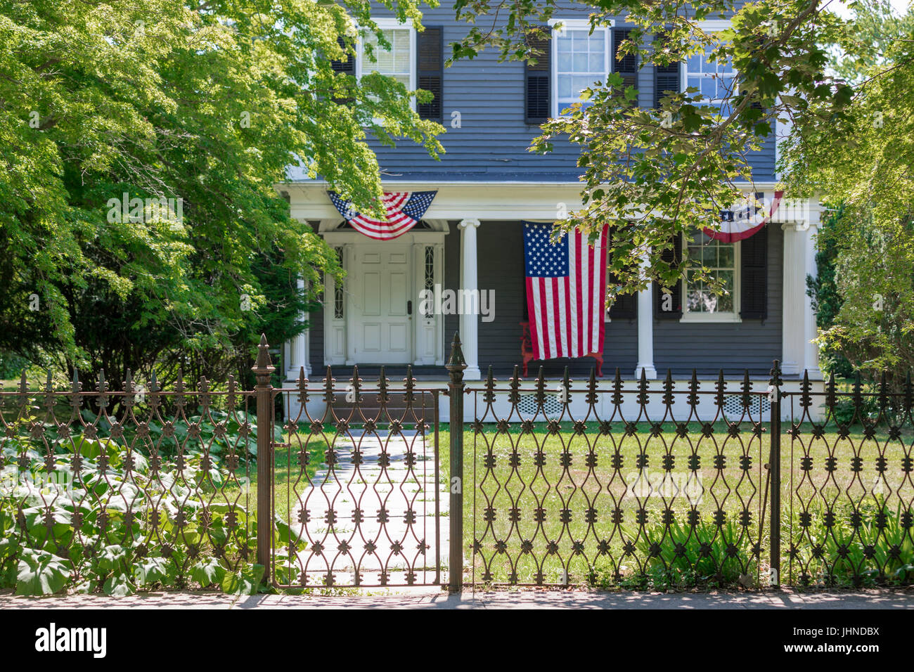 alten Sag Harbor Heimat auf der Hauptstraße mit patriotischen Fahnen und eine amerikanische Flagge auf der Veranda angezeigt Stockfoto
