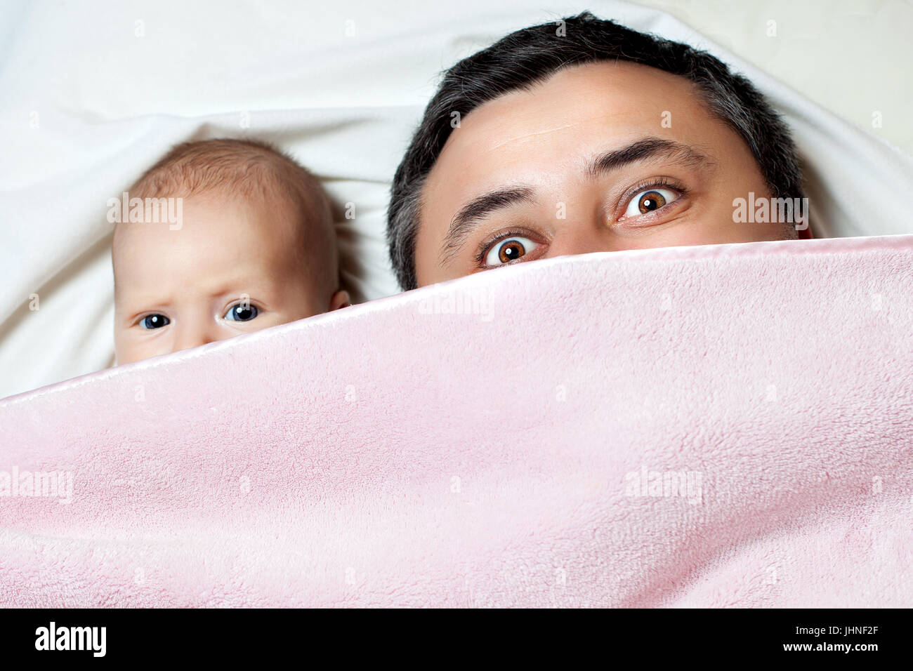 Vater und Tochter sind mit einer Decke bedeckt. Stockfoto