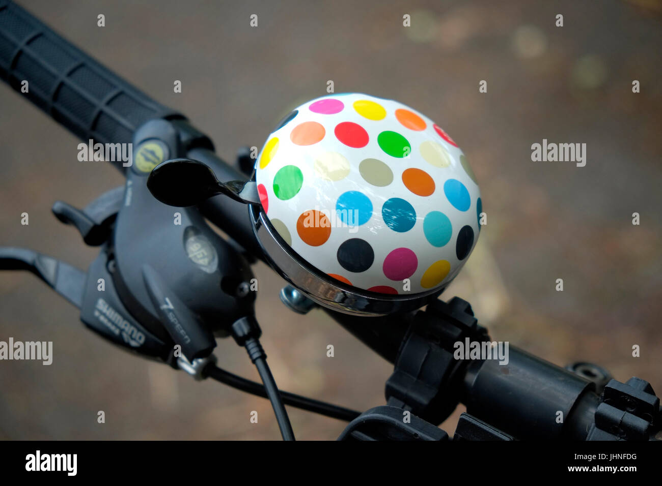 Eine Fahrradklingel mit mehrfarbigen Flecken gemalt. Stockfoto