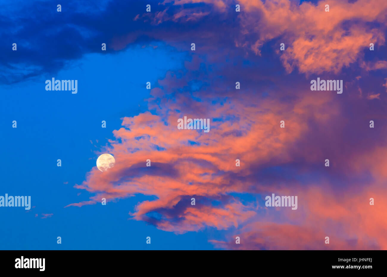 Vollmond in farbenfrohen Sonnenaufgang Wolken in der Nähe von Helena, montana Stockfoto