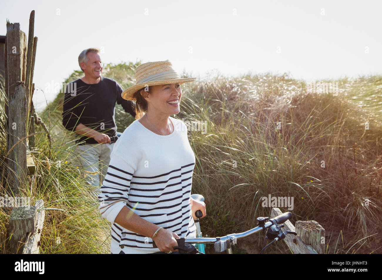 Älteres paar wenige Fahrräder entlang sonnigen Strandhafer Stockfoto