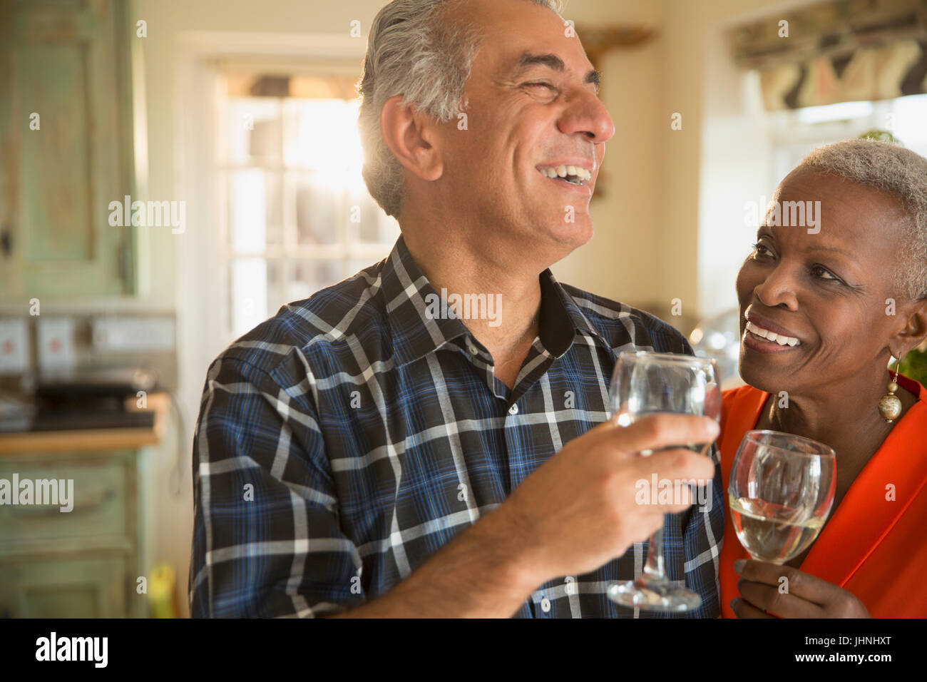 Älteres paar trinken Weißwein lachen Stockfoto