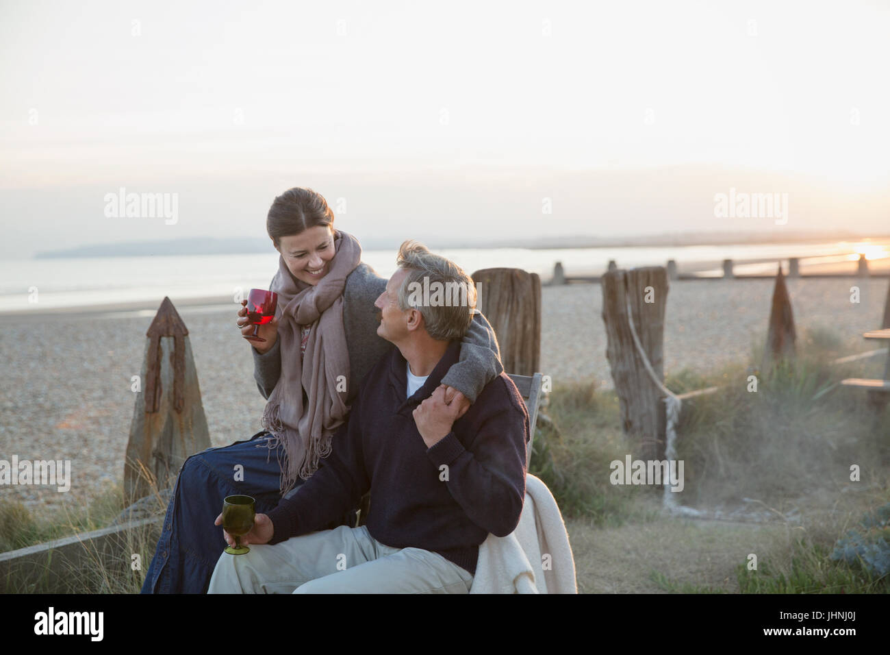 Liebevolle älteres paar Weintrinken am sunset beach Stockfoto