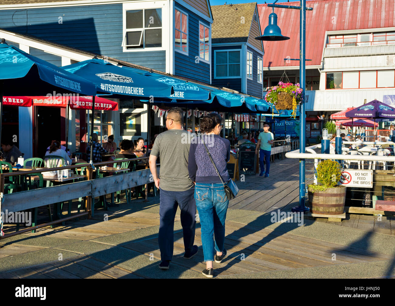 Menschen zu Fuß und Restaurants an der Strandpromenade meine Fishermans Wharf in Steveston British Columbia Kanada Stockfoto