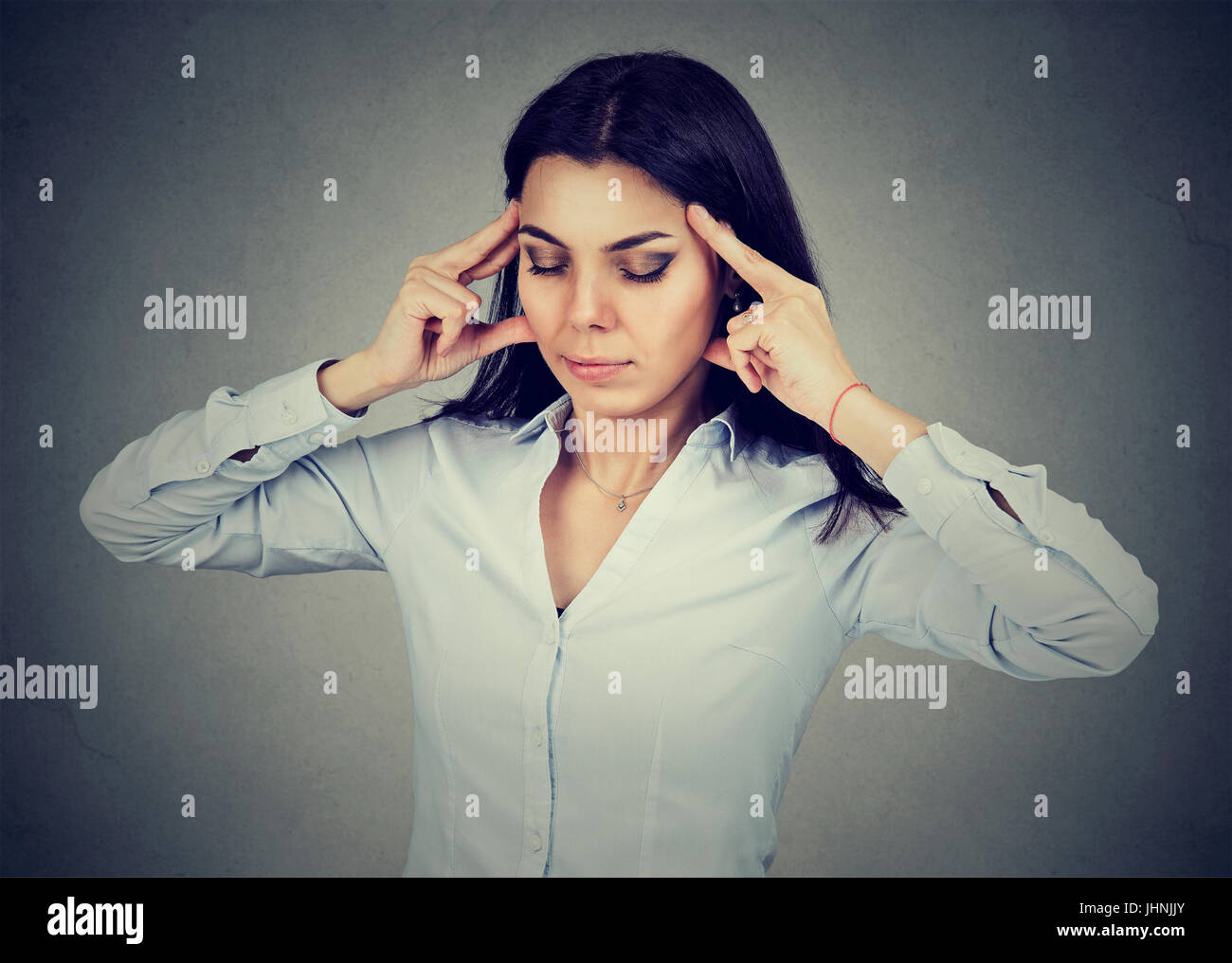 traurige junge Frau mit besorgt gestresster Gesichtsausdruck mit Kopfschmerzen Stockfoto