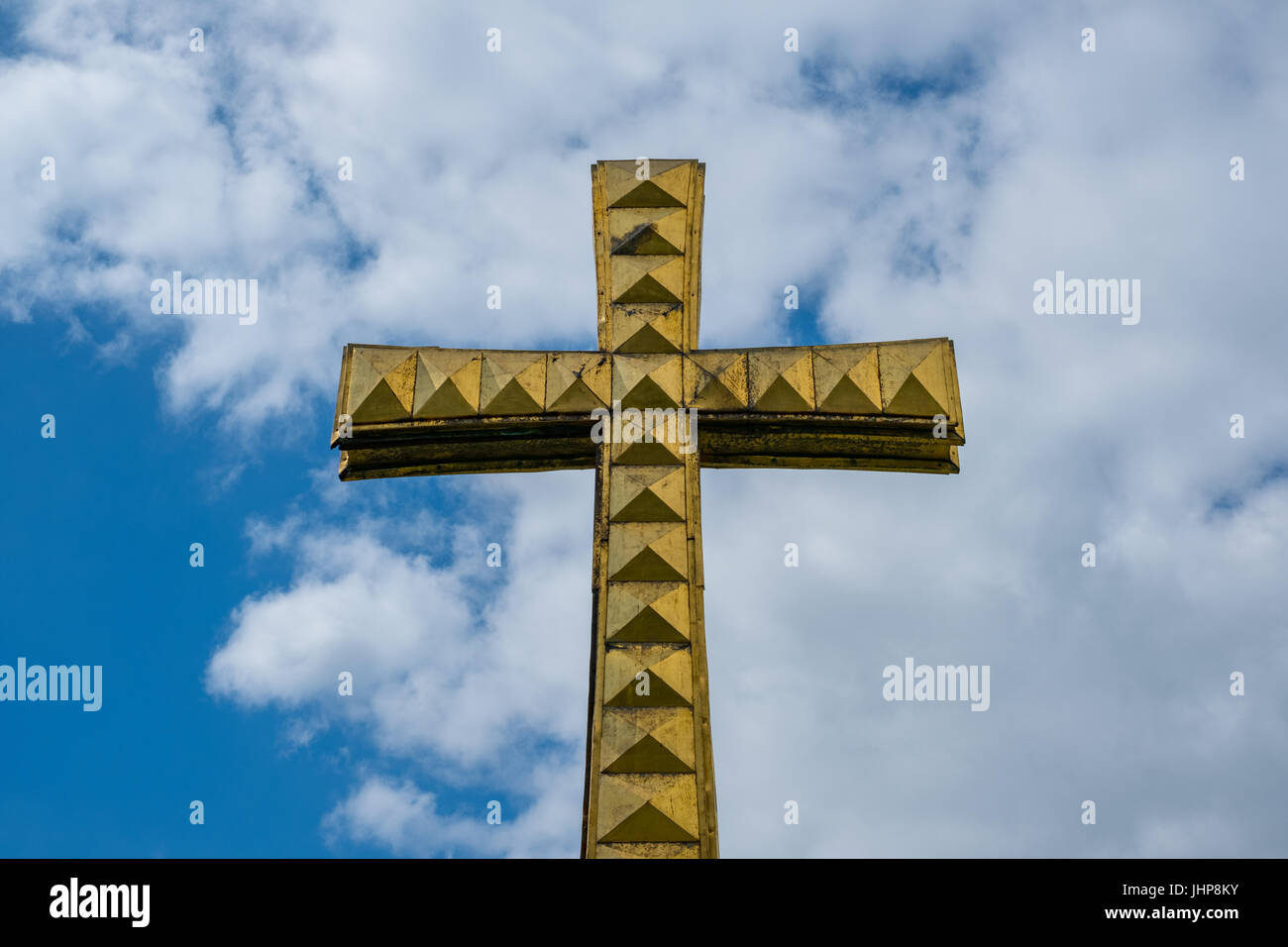 Goldenes Kreuz am Himmelshintergrund - Christentum Symbol isoliert Stockfoto