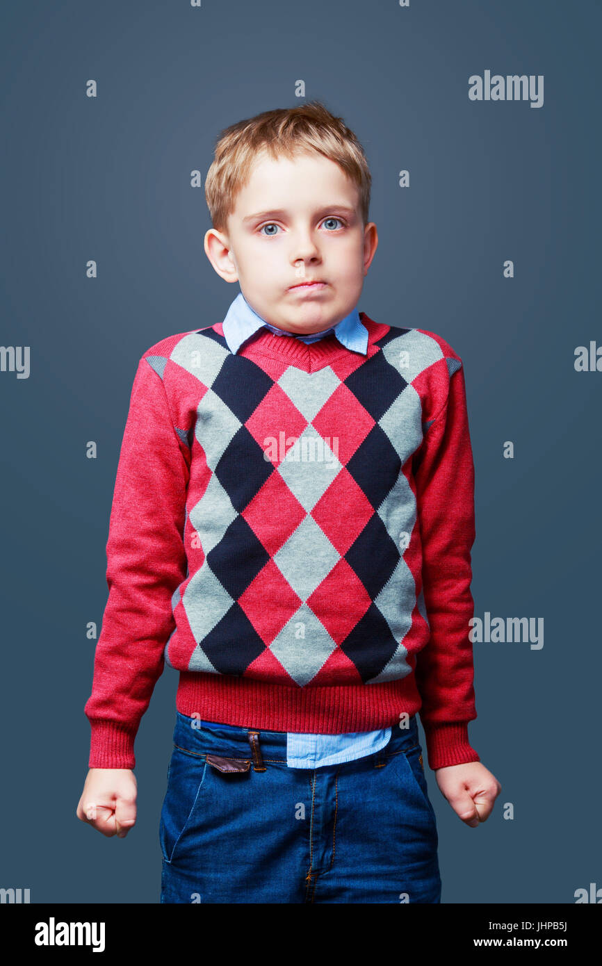 Peinlich wütend Junge gegen Grau isoliert Stockfoto