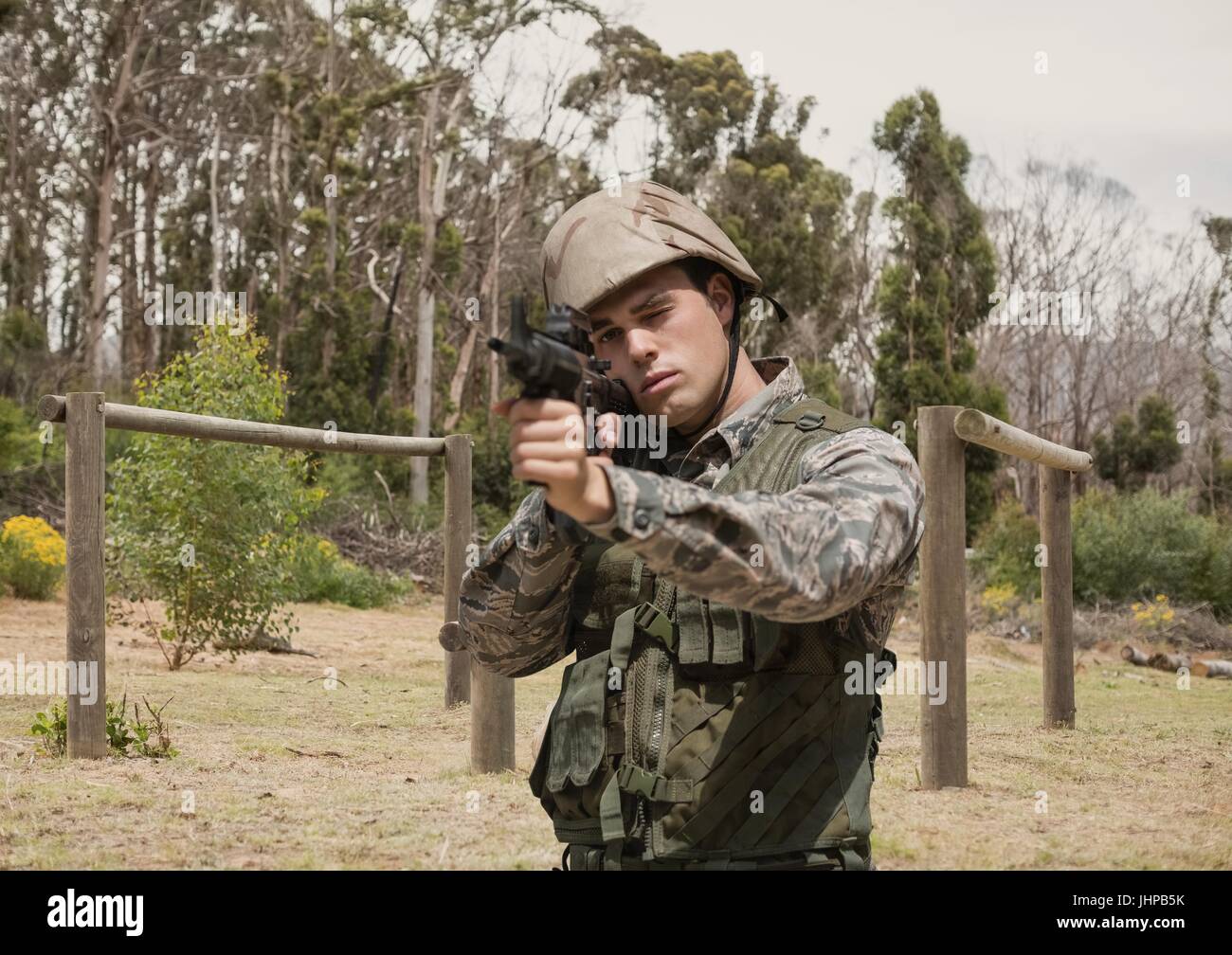 Digitalen Verbund aus Soldat Mann hält eine Waffe gegen Feld Stockfoto