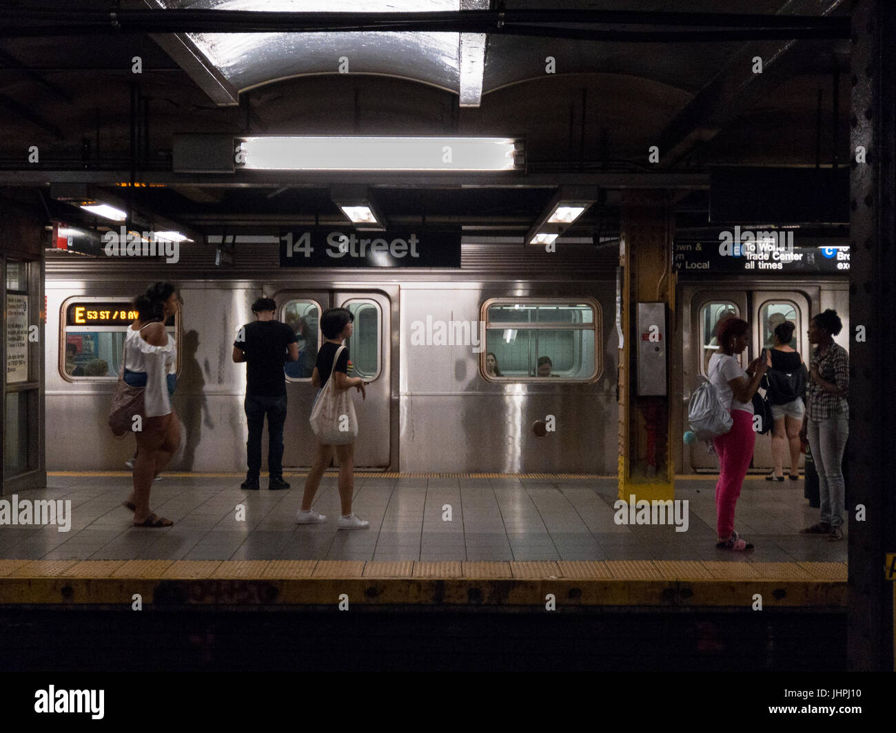 New York, NY--Menschen Sie 12. Juli 2017--warten auf den Zug an der New Yorker u-Bahn-Station an der 8th Avenue und 14th Street. Nur zur redaktionellen Verwendung Stockfoto