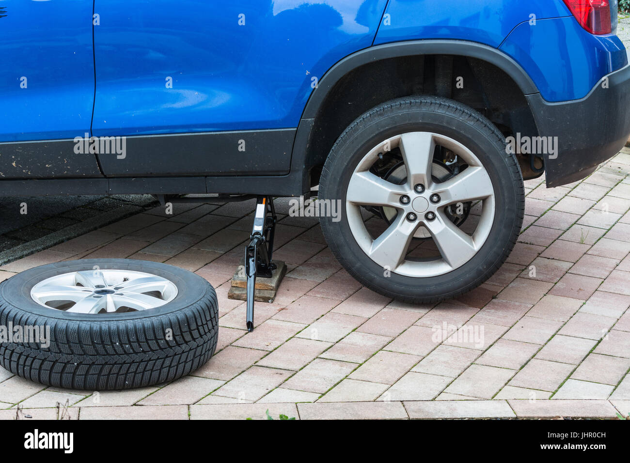 Junger Mann, den Austausch von Pkw-Reifen. Von Sommerreifen auf Winterreifen an seinem Auto. Stockfoto