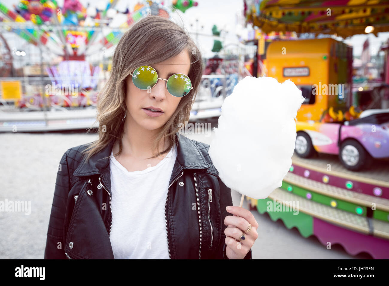 Schöne Frau mit Zuckerwatte im Vergnügungspark Stockfoto