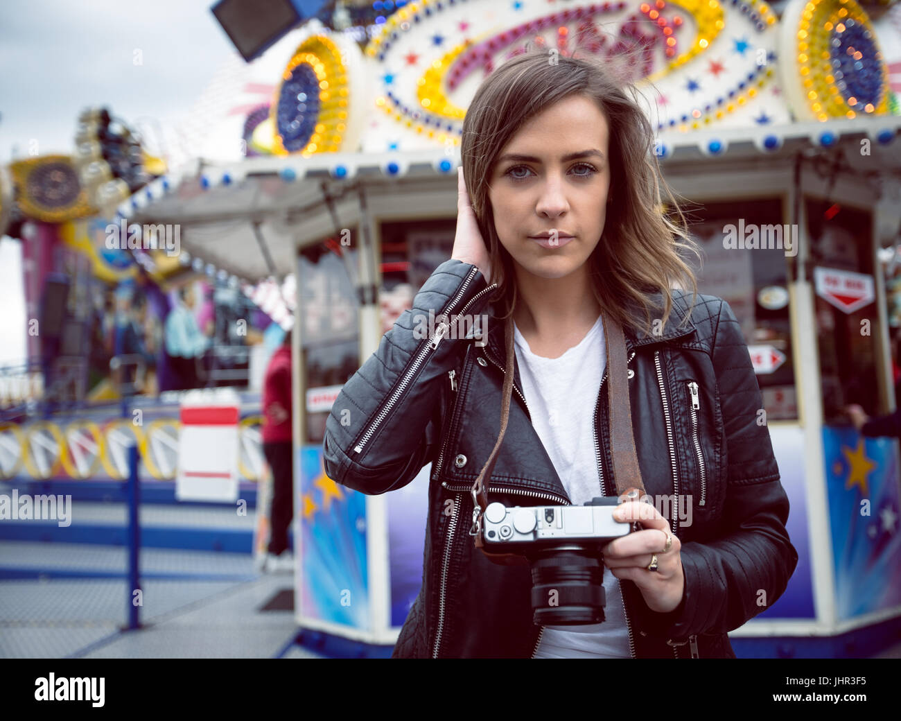 Portrait der schönen Frau mit Digitalkamera Vergnügungspark Stockfoto