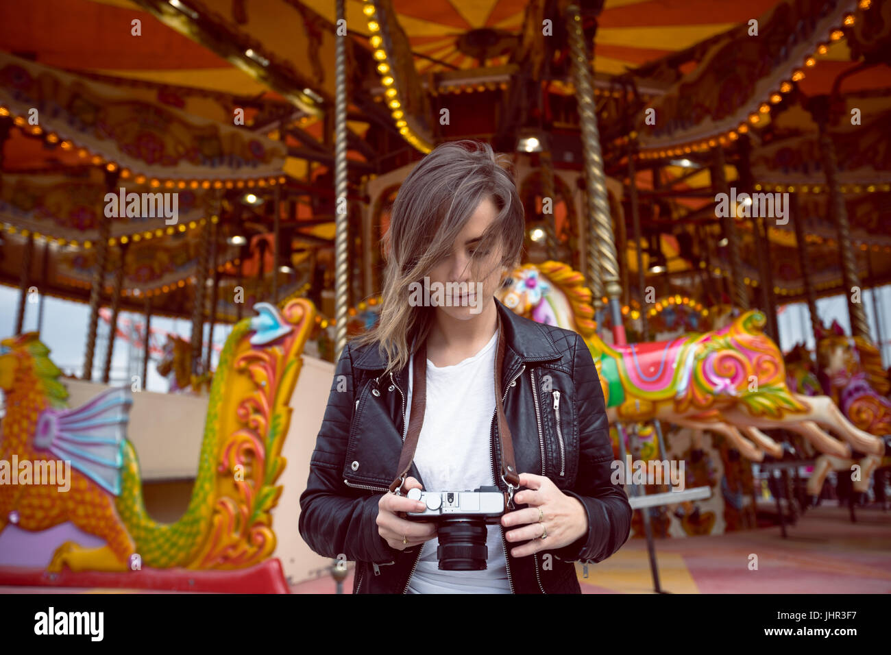 Schöne Frau, die Überprüfung der Fotos auf der Digitalkamera im Vergnügungspark Stockfoto