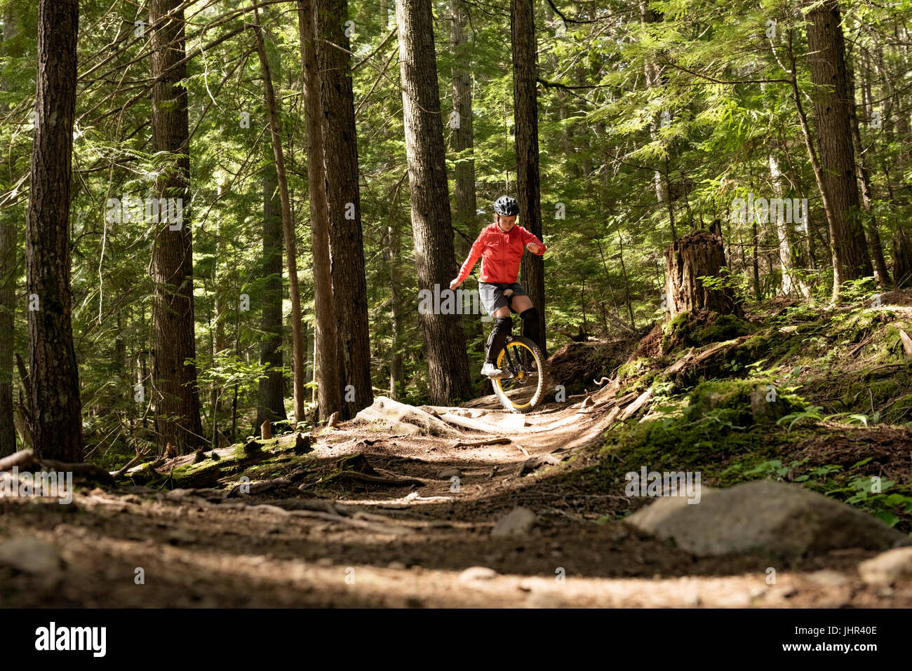 Übersicht über Frau Einradfahren vor Gericht gegen Bäume Oberfläche Stockfoto