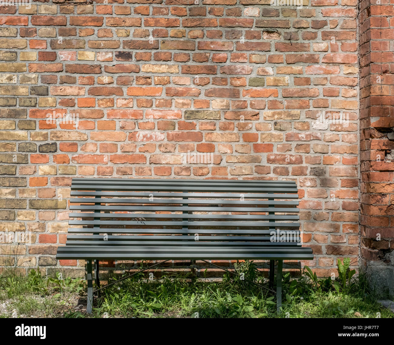 leere Holzbank mit Vintage Ziegel Wand Hintergrund - im freien Stockfoto