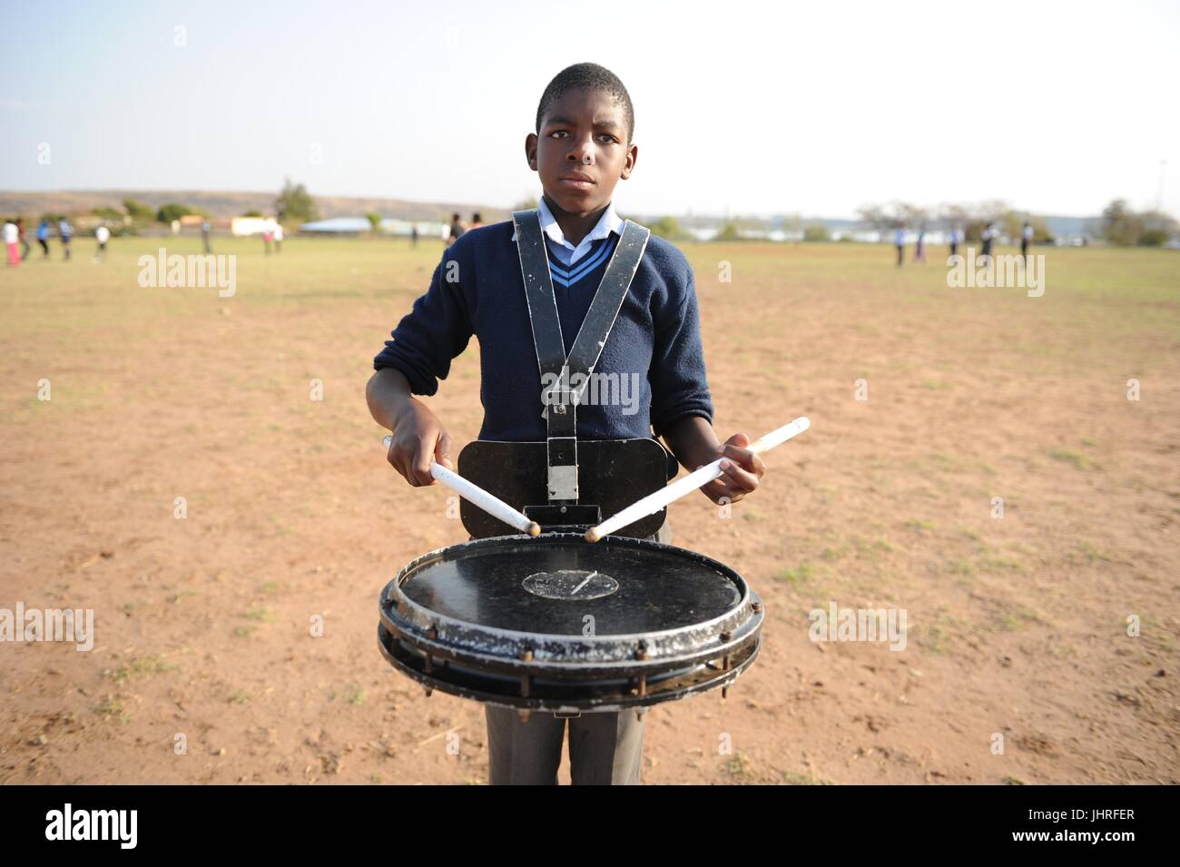 Ein afrikanischer junge spielt Schlagzeug in ein leeres Feld während der African Aerospace and Defense Expo 18. September 2012 in Pretoria, Südafrika.    (Foto: Benjamin Wilson über Planetpix) Stockfoto