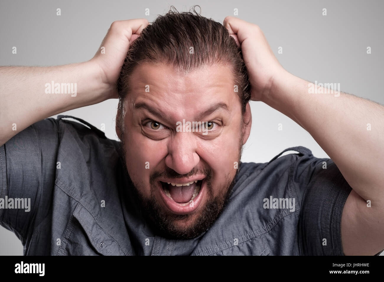 Closeup Portrait wütend, frustriert Mannes, seine Haare herausziehen. Negative Emotionen und Mimik Stockfoto
