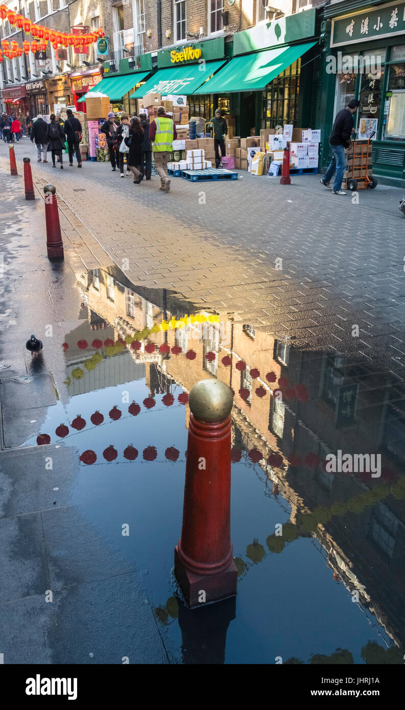 Reflexionen im Regenwasser, Lisle Street, Chinatown, London, England UK Stockfoto