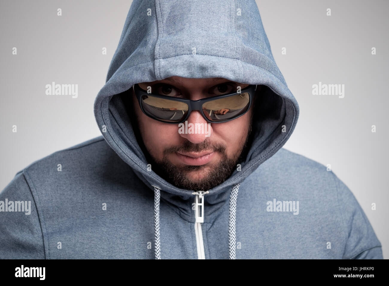 Eine geheimnisvolle bärtiger Mann mit Sonnenbrille versteckt unter einer Haube. Stockfoto