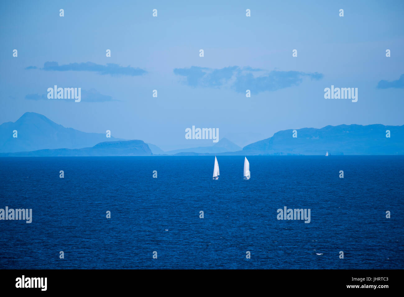 Zwei Boote Segeln zwischen Ardnamurchan und Lunga mit Rum, Muck, Eigg und Skye im Hintergrund, Juli 2017 Stockfoto