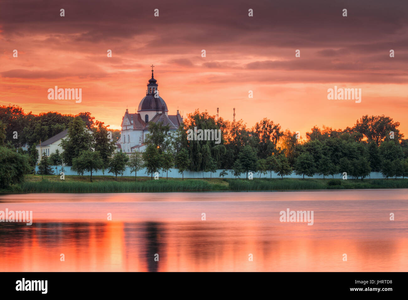 Neswizh, Region Minsk, Belarus. Corpus Christi Kirche und Burg Teich See im Sommer Sonnenuntergang am Abend oder morgen der Sonnenaufgang. Wahrzeichen In Nyasvizh. Stockfoto