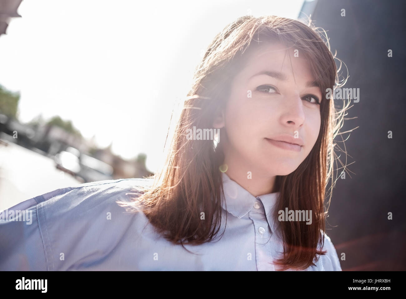 Schöne Frau Porträt im Freien mit Gegenlicht. Stockfoto