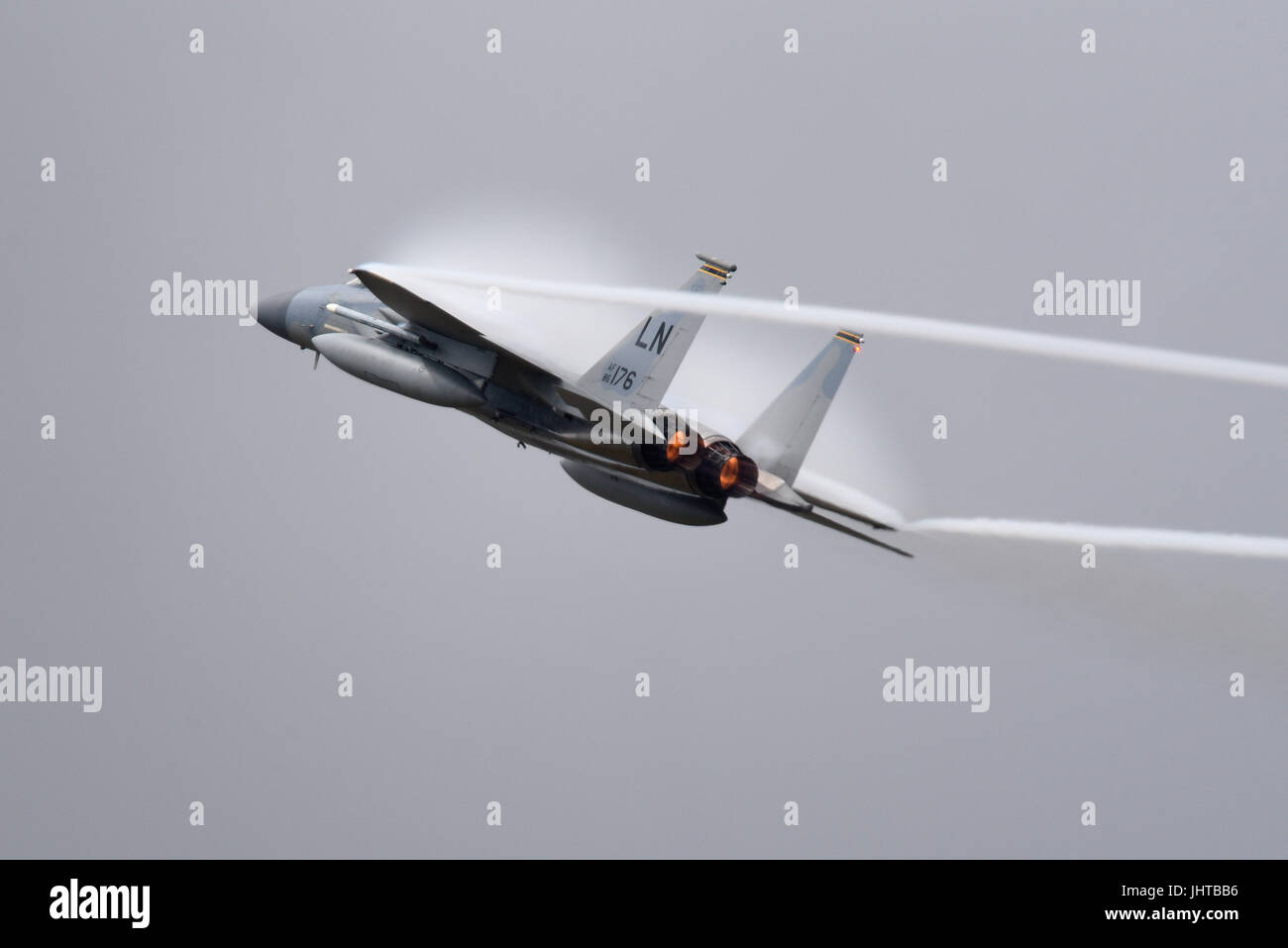 USAF McDonnell Douglas Boeing F-15 Eagle Kampfflugzeug von RAF Lakenheath, das bei einer Flugschau eine Hochgeschwindigkeits-Kraftdemonstration durchführte und eine Wolke aus Feuchtigkeit aus dem Druckluftdruck erzeugt Stockfoto