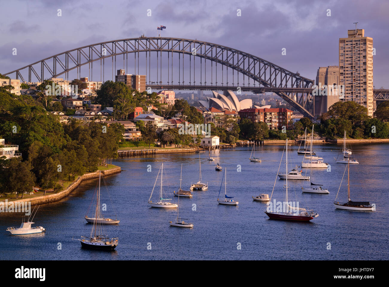 Malerische Stadtbild von Sydney Harbour mit Wohngebieten mit Schiffen und die Sehenswürdigkeiten von Sydney wie die Harbour Bridge und das Opernhaus. Stockfoto
