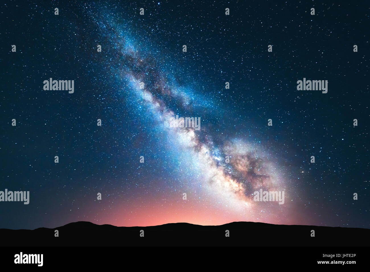 Milky Way. Fantastische Nachtlandschaft mit hellen Milchstraße Himmel voller Sterne, gelbes Licht und Hügeln. Glänzende Sterne. Malerische Szenerie mit unserem univers Stockfoto