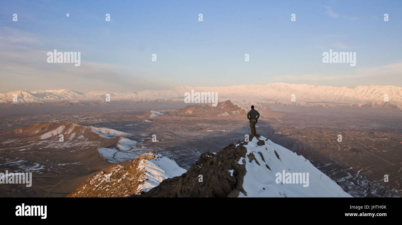 Ein US-Soldat Stand auf einem Hügel mit Blick auf eine verschneite Gebirge während des Afghanistan-Krieges 1. März 2013 in der Provinz Kabul, Afghanistan.    (Foto von Matthew Freire über Planetpix) Stockfoto