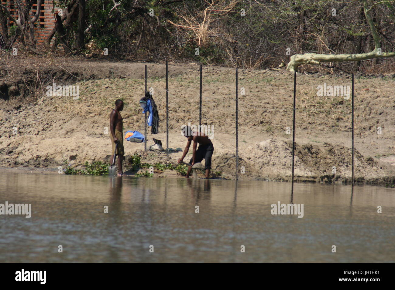 Afrikanische Männer arbeiten im Fluss von Nilpferd und Krokodil besetzt Stockfoto